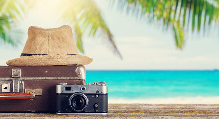 Poster - A bag with travel stuff, camera, and sun hat placed on a table