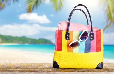 Poster - A beach bag with towels and sunglasses placed on a table