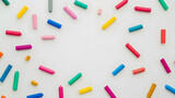 School background with colorful scattered crayons on white isolated background.  Art supplies,  school materials.