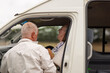 © Austockphoto - Middle aged man helping his son out of the van.