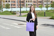 © Svetlana Verbitskaya - Woman crossing street with purple shopping bag in casual black outfit on a crosswalk.