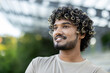 © Liubomir - Young happy man with close-up smiling and looking to the side, wearing a t-shirt walking through the city and park.