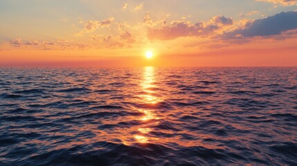 Wall Mural - The sun sets over the tranquil ocean, casting golden and orange hues across the water. Gentle waves reflect the colors as the day transitions to evening, creating a serene atmosphere