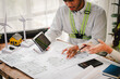 © Suphakant - Engineers work as a team with blueprints for architectural plans. Engineer sketching construction project concept with architect equipment Architects talking at table Teamwork and construction concept