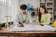 © Suphakant - Engineers work as a team with blueprints for architectural plans. Engineer sketching construction project concept with architect equipment Architects talking at table Teamwork and construction concept