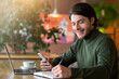 © Prostock-studio - Young businessman working with laptop at cafe, using phone and taking notes, copy space
