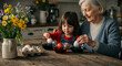 © Viktorija - children and grandmother pouring and colouring easter eggs