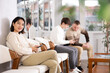 © JackF - Girl sits in lobby of employment office, waiting for interview or conversation with career consultant. Watches news on Internet via a smartphone