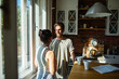 © Marko Geber - Happy couple embracing in sunny kitchen