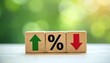 © miss irine - Wooden cubes display interest rates and mortgage rates concept with percentage symbol, arrow up and down on nature background. Economic indicator of financial trends and stock market predictions.