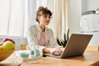© LIGHTFIELD STUDIOS - Creative young woman working on a laptop in a bright apartment during the afternoon
