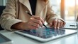 © Vadym - Businesswoman works on tablet at office, signs documents with stylus. Graphs on screen. Digital signature application. Woman employee uses modern tech for company project management, cyberspace
