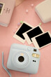 © Arina Cristalova - Instant Polaroid photos, a camera for instant printing, and photo albums on a soft pink background, evoking nostalgia and memory preservation.