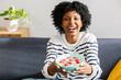 © Xavier Lorenzo - Young happy African American woman enjoying a healthy breakfast at home on a cozy winter morning, holding a bowl of yogurt with fresh fruits and seeds. Healthy lifestyle and eating concept