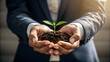 © Mobasser - Growth in Hands: An individual in a suit cradles a budding sprout in cupped hands, symbolizing growth, development, new beginnings, and sustainability.