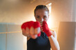 © Юлия Завалишина - Women self defense girl power. Strong woman fighter punching with red boxing wraps sports protective bandages. Girl punching training punches looking concentrated straight. Fit body workout