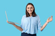 © Pixel-Shot - Young businesswoman with laptop on blue background