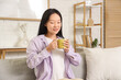 © Pixel-Shot - Young Asian woman drinking coffee at home