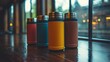 © mlangsen - Colorful Thermoses lined up on Wooden Counter near Window with blurry background