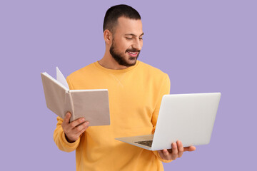 Wall Mural - young man with laptop and book on lilac background