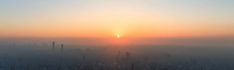 Aufkleber - Sunrise over a hazy city skyline, casting warm hues across the horizon.
