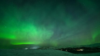 Wall Mural - Dazzling Aurora Borealis Lights In Night Sky Over Winter Landscape In Kvaloyvaagen, Norway. timelapse
