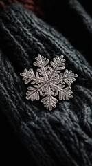 Aufkleber - Close-up view of a stunning snowflake resting on dark knitted fabric
