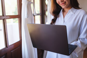 Wall Mural - closeup of a woman holding and working on laptop computer at home