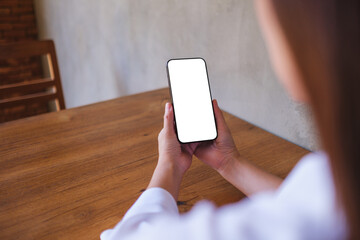 Wall Mural - mockup image of a woman holding black mobile phone with blank desktop screen