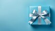 © Eli - Pastel Blue Gift Box with Silver Ribbon on Pastel Blue Background. Top View of Birthday Gifts with Copy Space