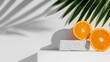 © Grapy Media - Minimalist Tropical Still Life with Orange Halves and Palm Leaf Casting Shadow on White Wall