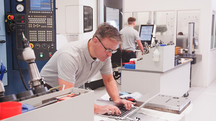 Wall Mural - mature male engineer in factory using cad programming software on laptop