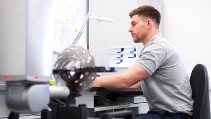 Wall Mural - male engineer uses cmm coordinate measuring machine in factory