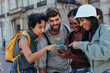 © bernardbodo - Group of tourists using smart phone for navigation in european city
