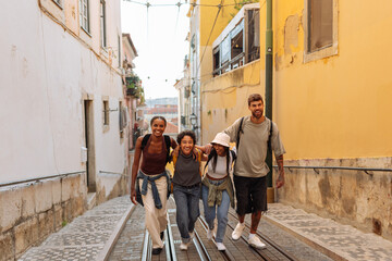 happy tourists walking downhill on tram tracks in lisbon, portugal