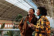 © bernardbodo - Tourists consulting smart phone inside railway station in madrid