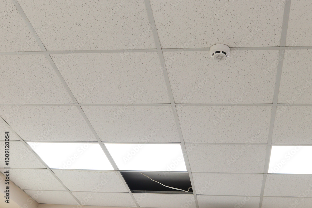 ceiling with a suspended system made of white acoustic panels in a ...