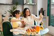© Alberto - Mom and daughter taking selfie while preparing chocolate cookies in kitchen