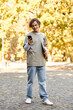 © LIGHTFIELD STUDIOS - Stylish young man enjoying a sunny day outdoors while checking his phone in a park
