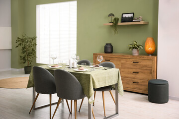 Aufkleber - Stylish table setting with olive tablecloth, glasses and candles in dining room