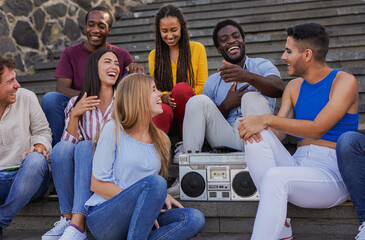 group of multiracial people having fun together sitting in the city and listening music with vintage