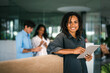© NDABCREATIVITY - Smiling black successful business woman, freelancer, coworker female leader using digital device