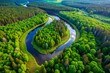 © Image - Aerial view of a winding river through a lush green forest in Tuchola Natural Park—serene and scenic beauty