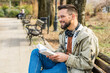 © Srdjan - Young curious religious man, reading a book about religion, while sitting in the park on bench. Finding God male, happy and hungry for knowledge about faith. Christian or muslim read Bible or Quran.