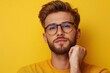 © aimodels24 - Thoughtful Man with Glasses Posing Against Bright Yellow Background