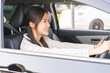 © KMPZZZ - Transport, happy smile brunette hair asian young woman hand holding steering wheel driving car, vehicle for travel trip, sits on driver seat, female with fasten safety seat belt before traveling.