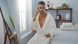 © Krakenimages.com - Handsome man in spa reading document while talking on phone showing relaxation and beauty indoors