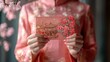 © Chirawan - Woman in Pink Traditional Clothing Holding Red Floral Envelope