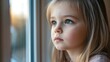 © NN AI - Little girl with braided hair looking thoughtfully by window with urban view. Child with serious expression against city backdrop. Child psychology, education, family support. Horizontal banner