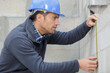© auremar - building worker measuring the wall at construction site